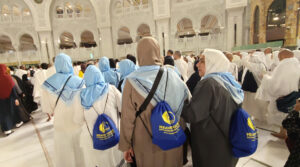 Heaven Tours Umrah pilgrims inside Masjid Al-Haram Makkah with Heaven Tours bags